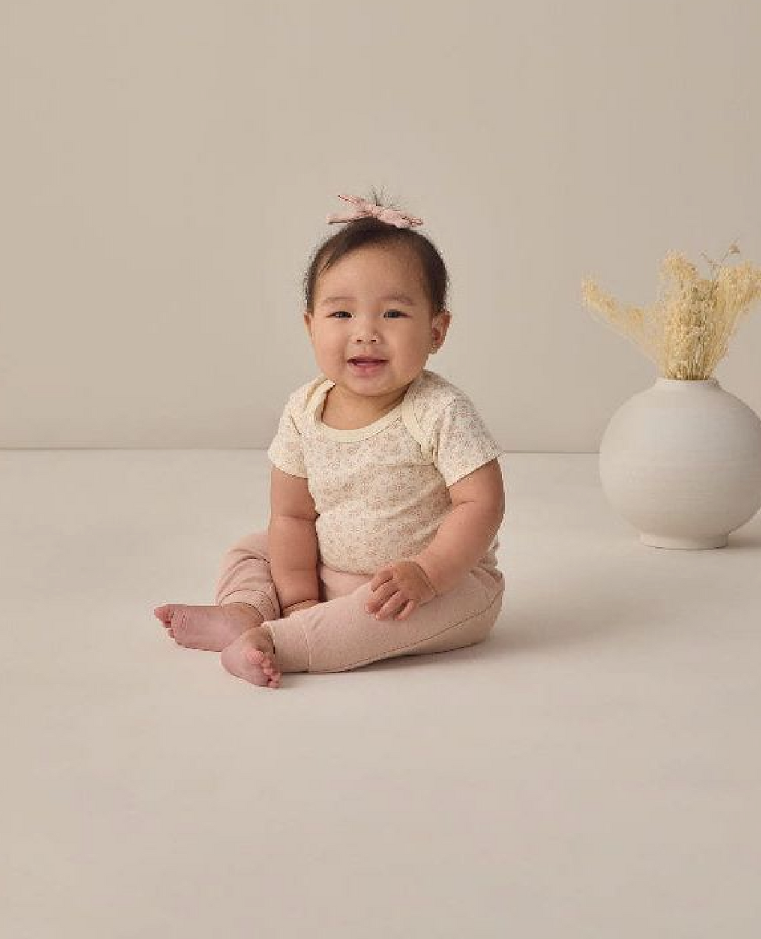 Maturing baby in onesie and bow