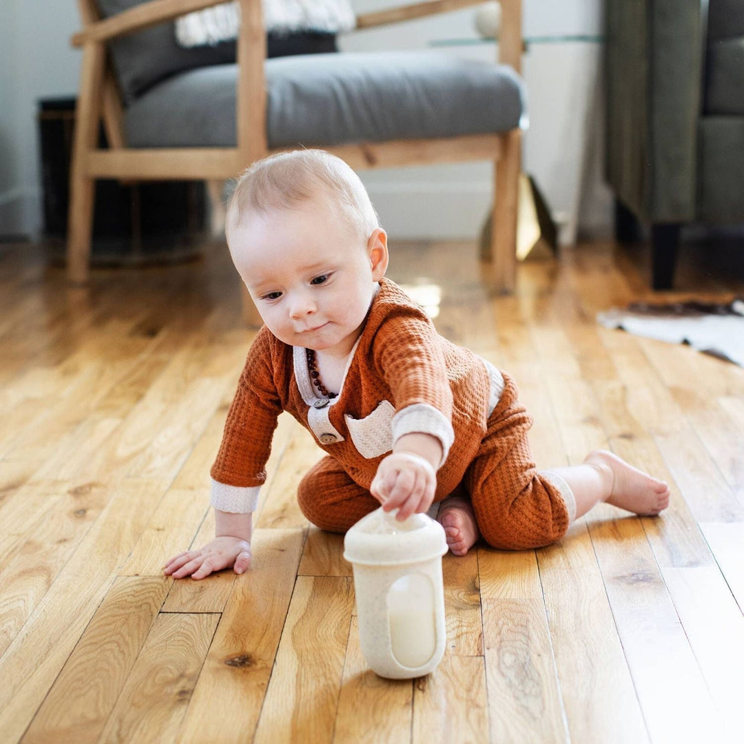 baby hold bottle on the ground