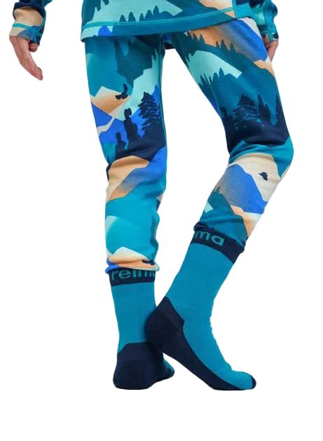 A person wearing blue patterned pants and matching blue socks with dark navy toe and heel areas, shown from the waist down against a light gray studio background.
