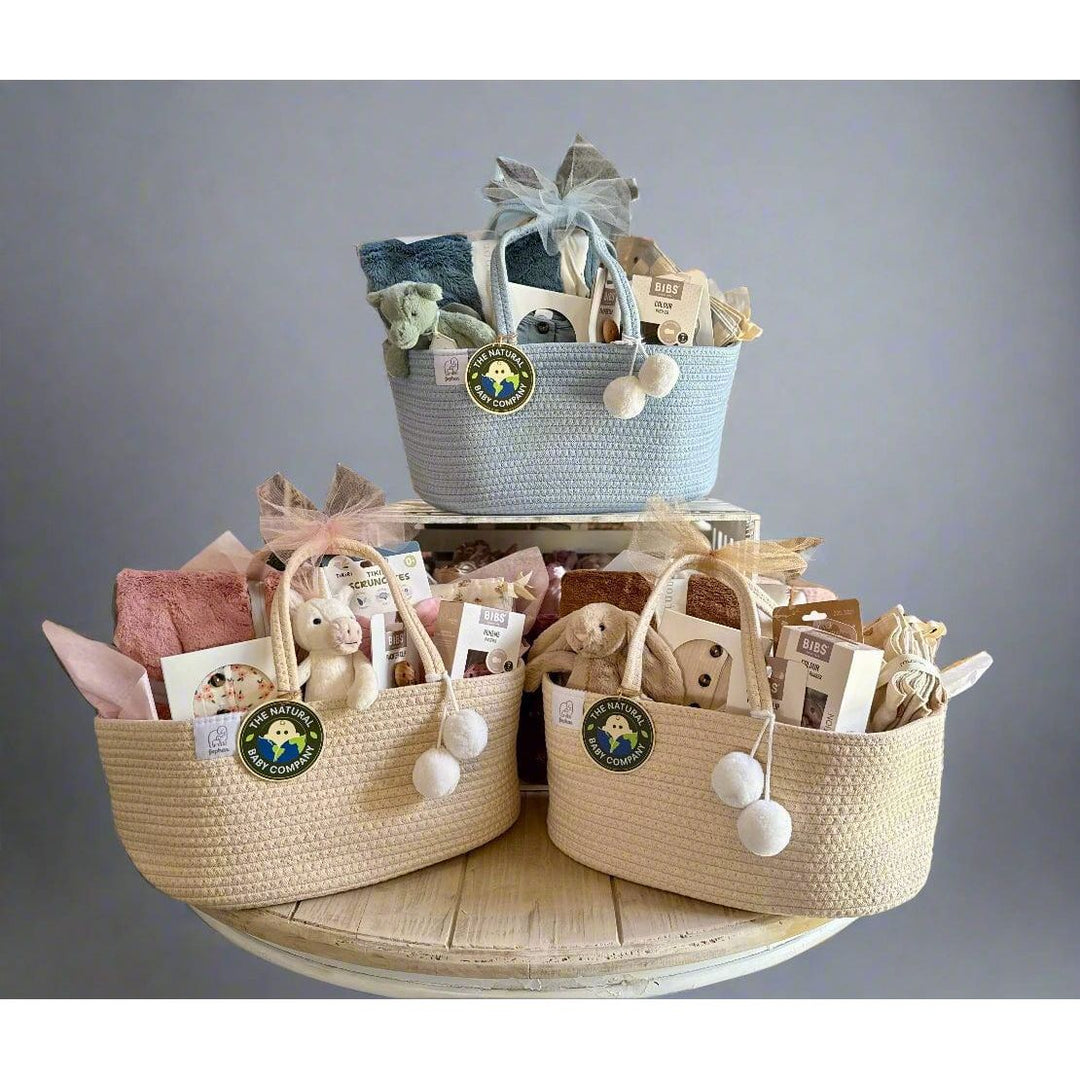 Three woven baskets with baby items on a table in a store setting
