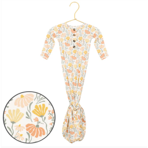 Floral-patterned baby onesie on a hanger with a close-up inset of the pattern.