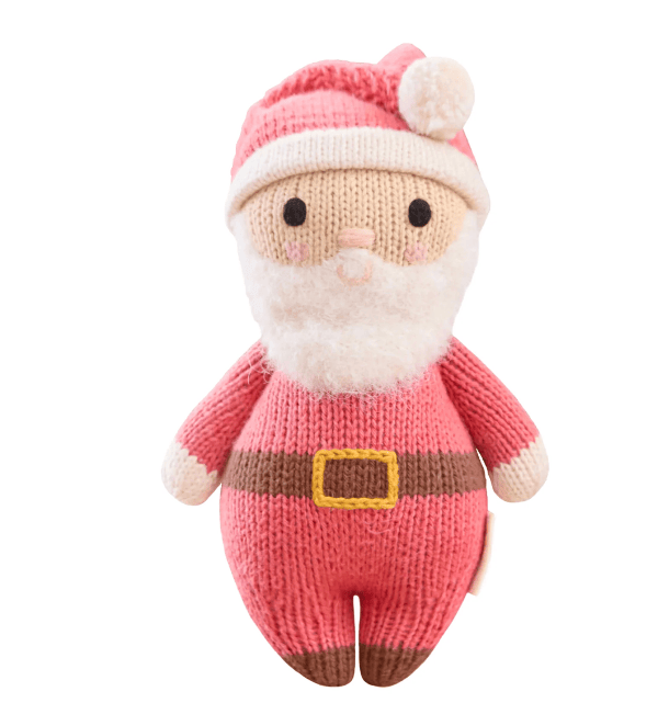 A knitted Santa Claus plush toy in pink and white with a brown belt and gold buckle detail, photographed against a solid white background.