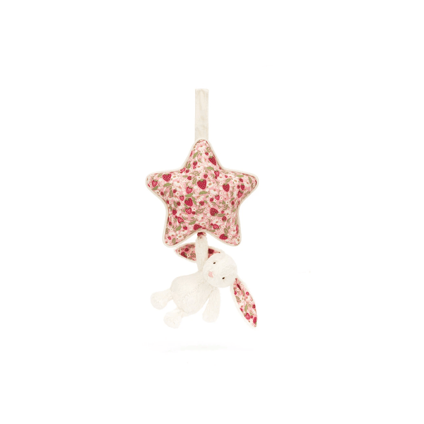 A baby plush toy featuring a star-shaped fabric top with a red and green strawberry pattern, hanging from a cream ribbon, with a small cream bunny plush dangling below.
