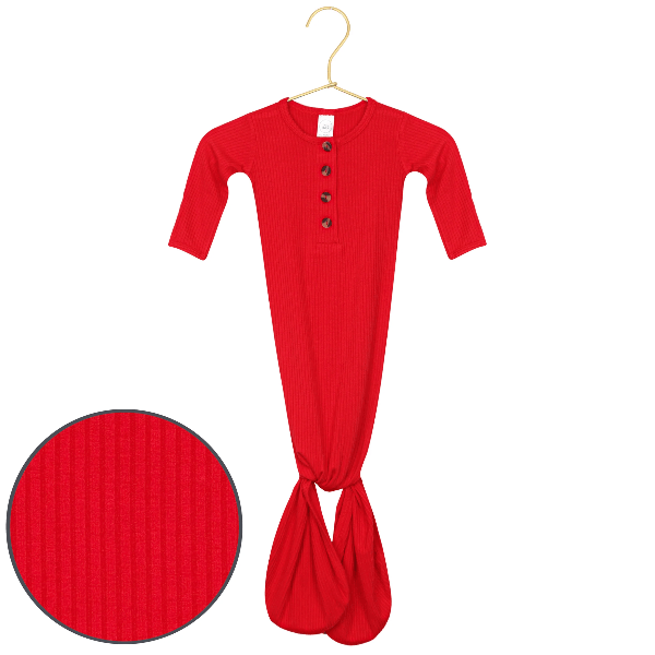 A bright red ribbed baby gown with long sleeves, a buttoned henley-style top, and a twisted leg detail at the bottom, shown on a hanger with a circular fabric close-up inset.