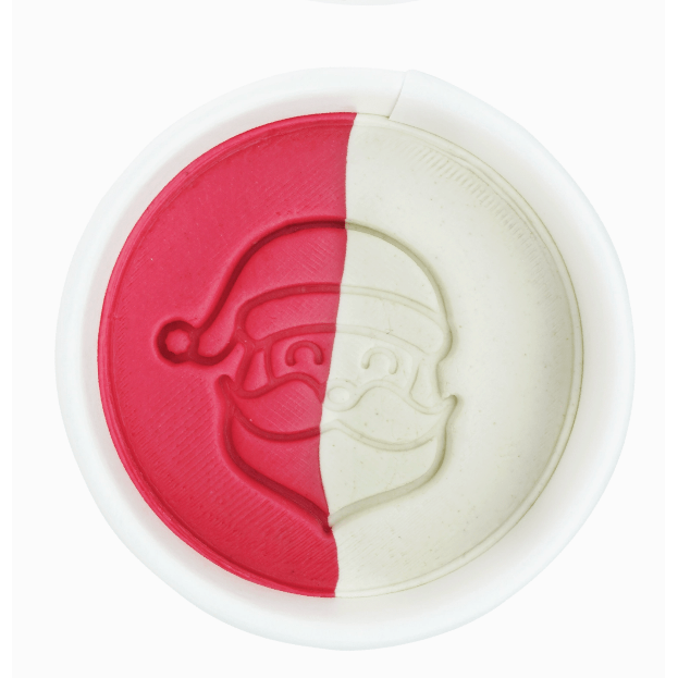 Cookie cutter with red and white halves, each shaped like a face with a hat and beard.