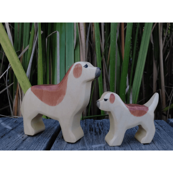 Two ceramic dog figures on a wooden surface with a natural background