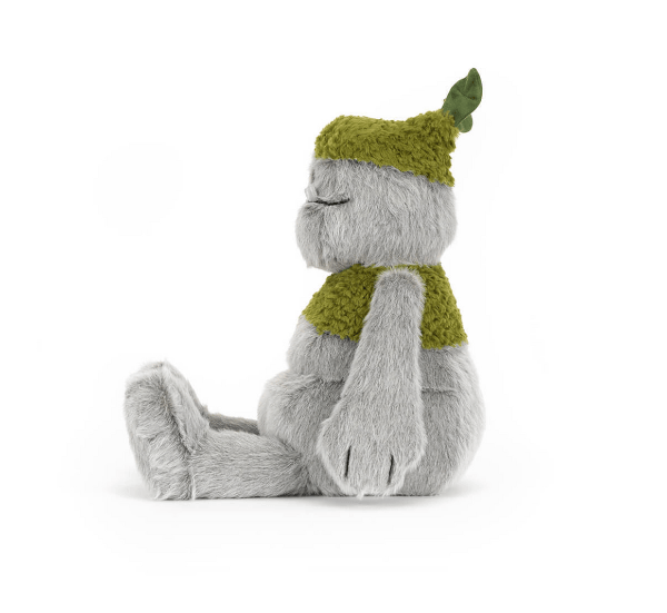 Plush toy resembling a creature with a green hat and scarf on a white background
