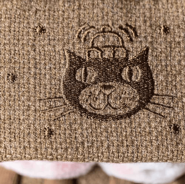 Close-up of a cat face design embroidered on fabric.