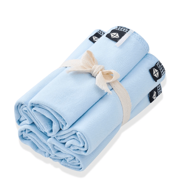 Light blue towel with a white string tied around it on a white background