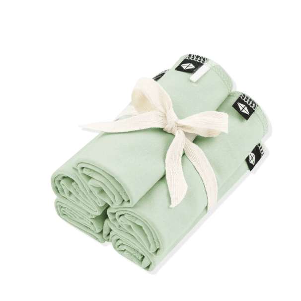 Folded green fabric with a white ribbon on a white background