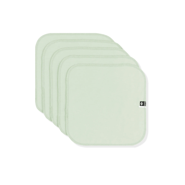 Set of four light green square cushions on a white background