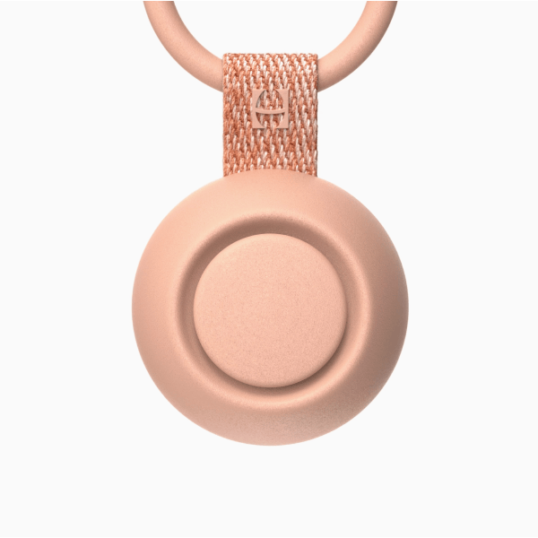 Round beige device with a chain on a white background