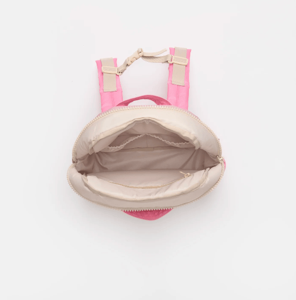 A top-down view of a small pink backpack with an open cream-colored zipper and interior, set against a plain white background.