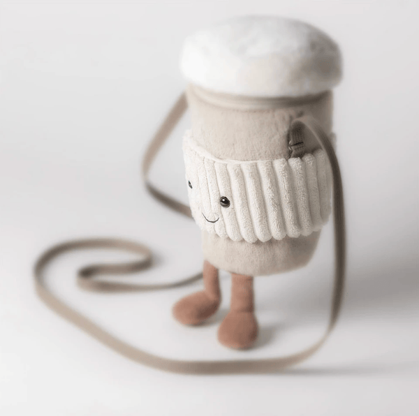 A plush coffee cup character bag with a cream-colored knit sleeve, white fluffy top, and small brown legs, shown on a clean white background.