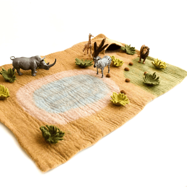 A felt safari-themed rug featuring a textured landscape with a watering hole, a rhinoceros, a zebra, a giraffe, and small green bushes, shown on a white background with small animal figurines.